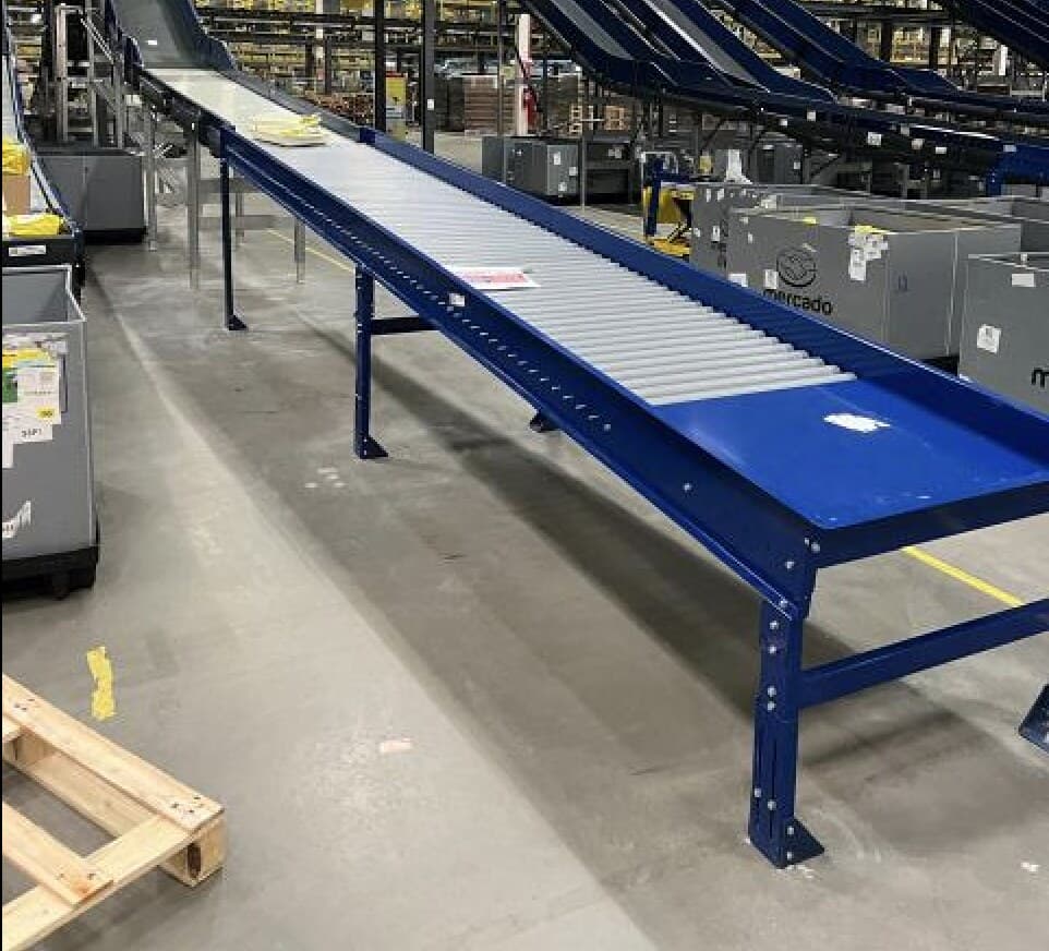 Esteira de roletes em estrutura azul e esteiras inclinadas num centro de distribuição